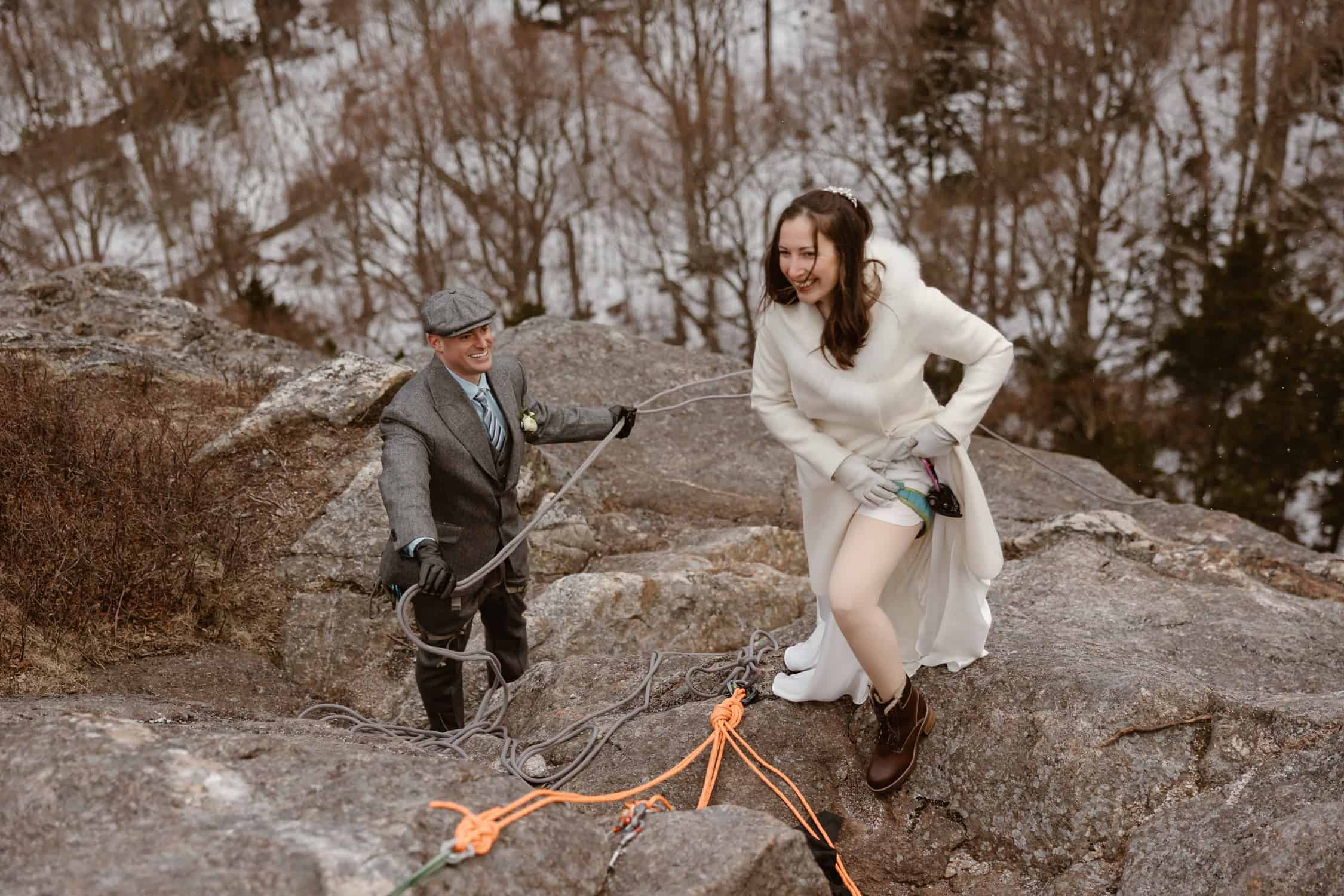 A bride and groom clipping in, preparing to rappel down Artist's Bluff on their adventurous elopement day.