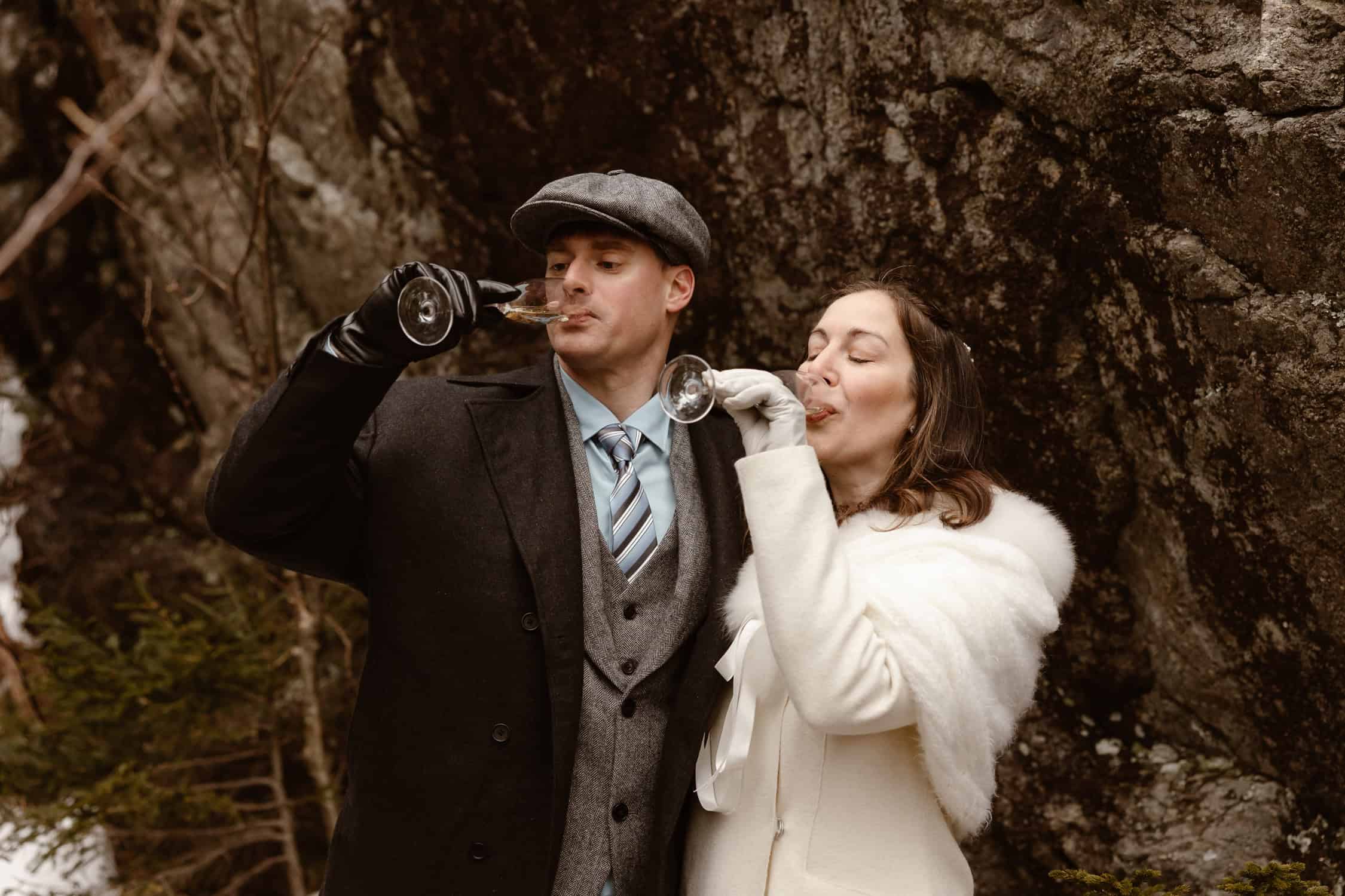 A couple drinking champagne, celebrating their rappel elopement.